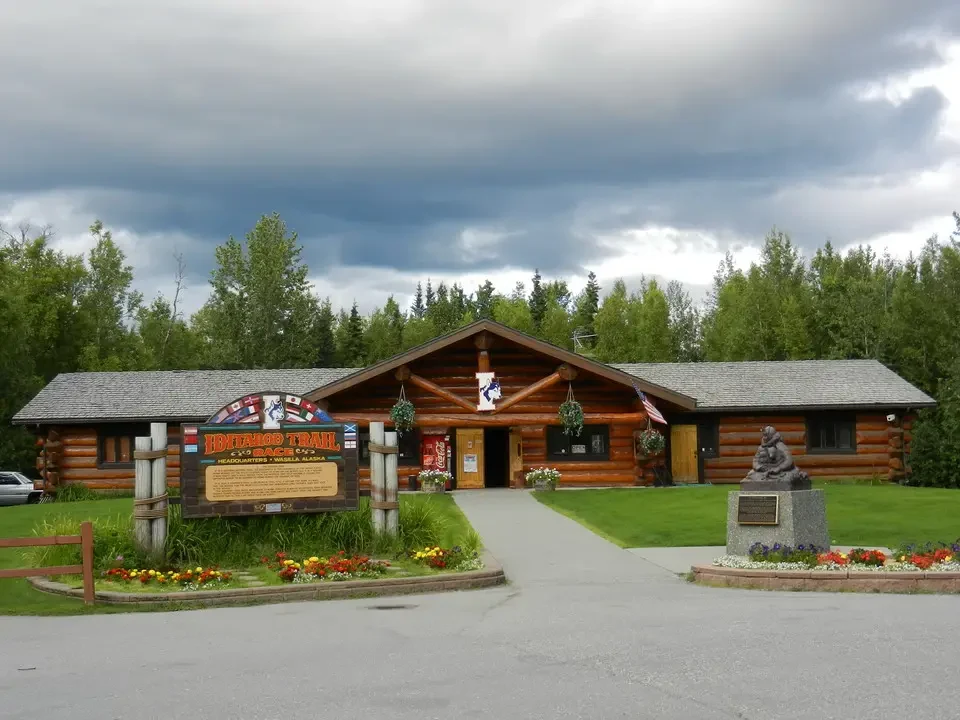 La sede del campeggio Iditarod Trail è visibile con un edificio in legno.