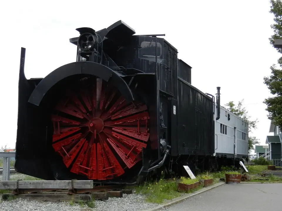 A black steam locomotive with red wheels is displayed on tracks.