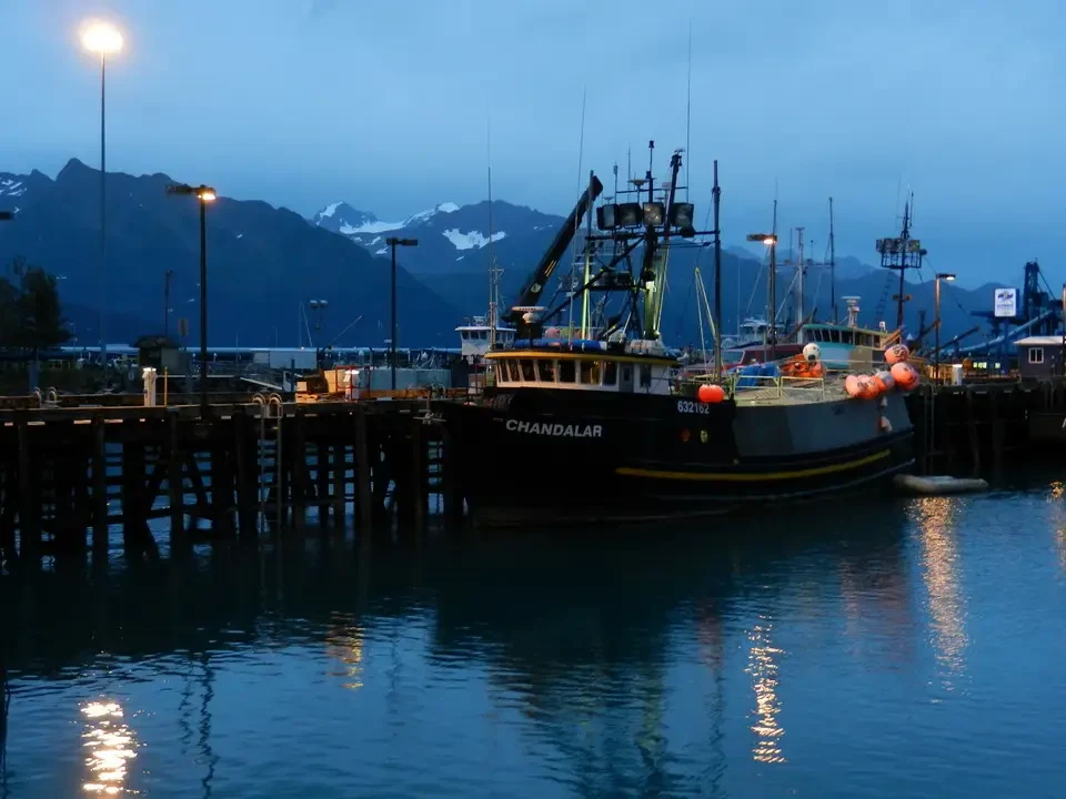 A small boat moored in a harbor at dusk.
