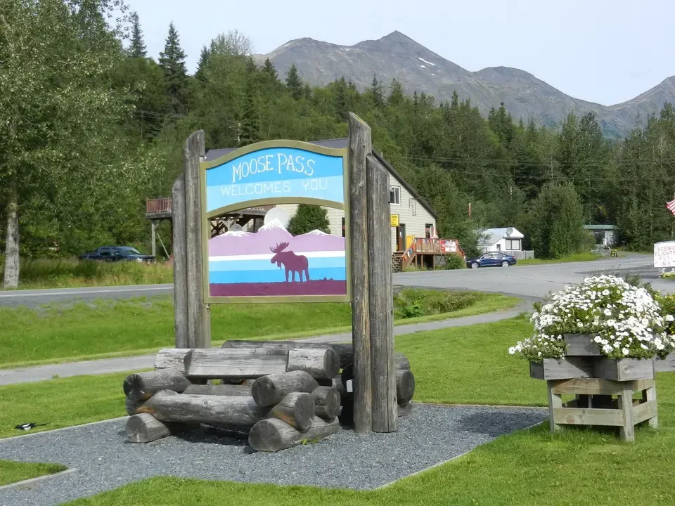 Welcome sign to Moose Pass with a moose.