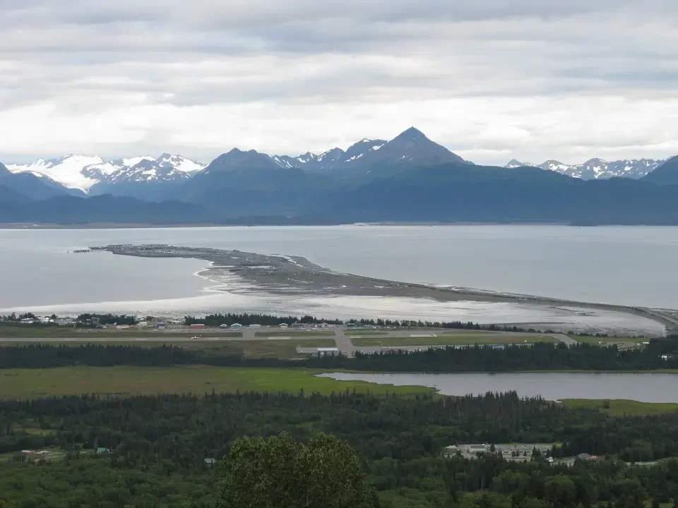 Mountain landscape with a body of water in the foreground and a coastline.