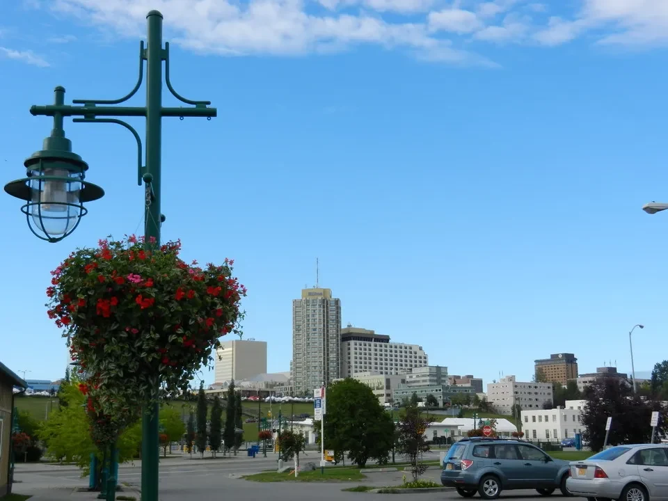 A panoramic view of the city with buildings and trees under a blue sky.