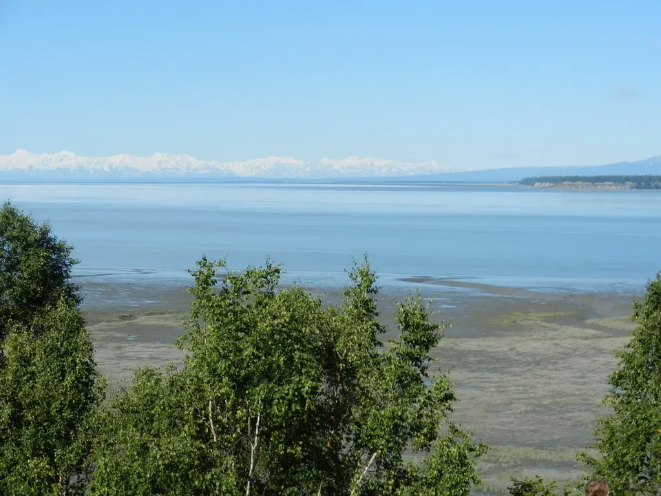 A vast lake with snow-capped mountains loom in the background.