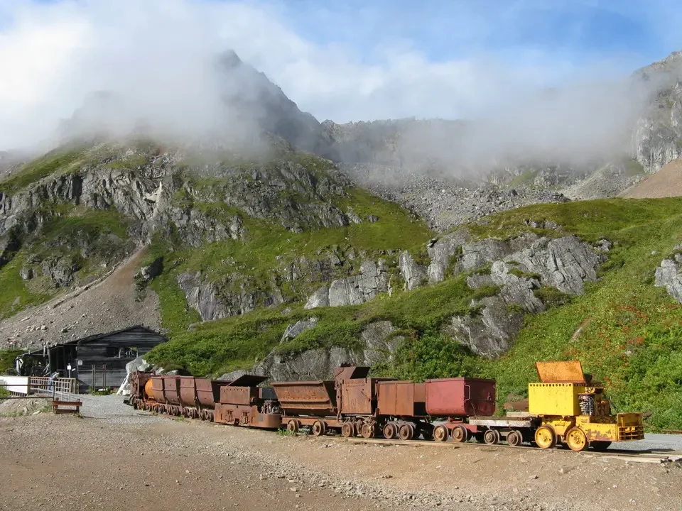Freight trains pass through a foggy mountain landscape.