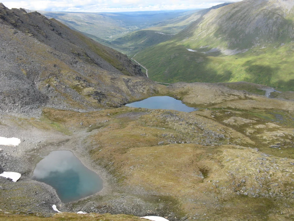 Mountain landscape with alpine lakes and a green valley.