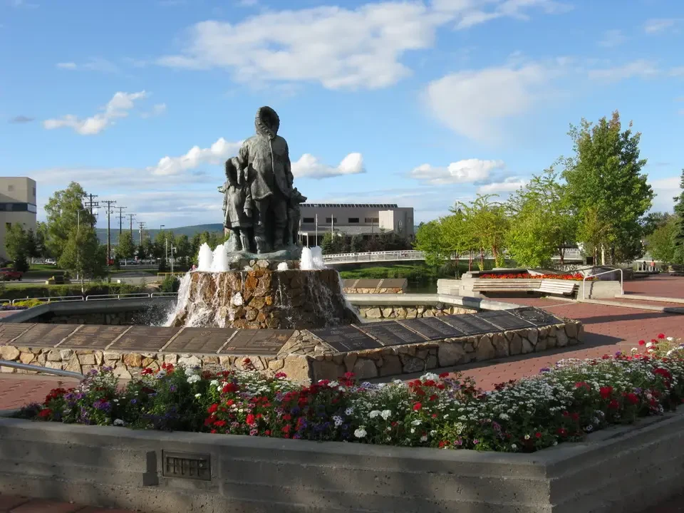 A statue of a standing figure is placed on a decorative fountain.