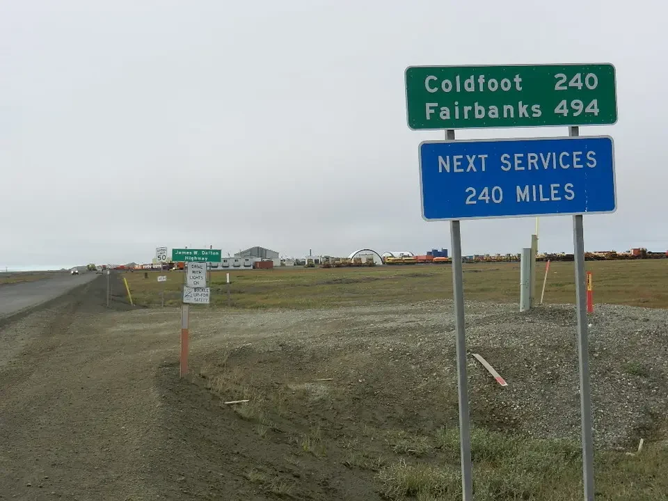 Road signs indicate distances and destinations along a rural road.