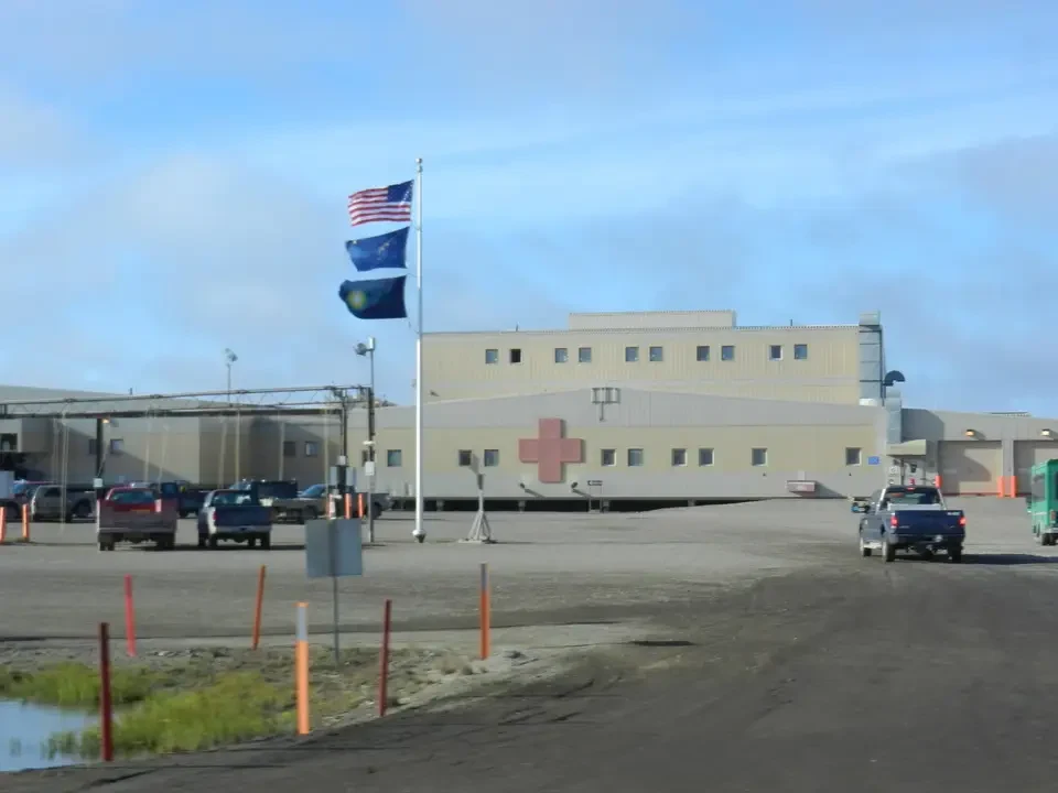 A military base with waving flags sprawls across an open field.