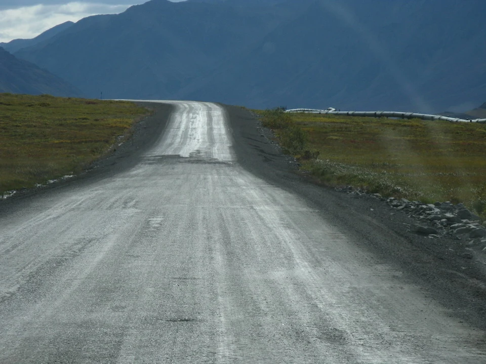 An asphalt road winds through a mountain landscape.