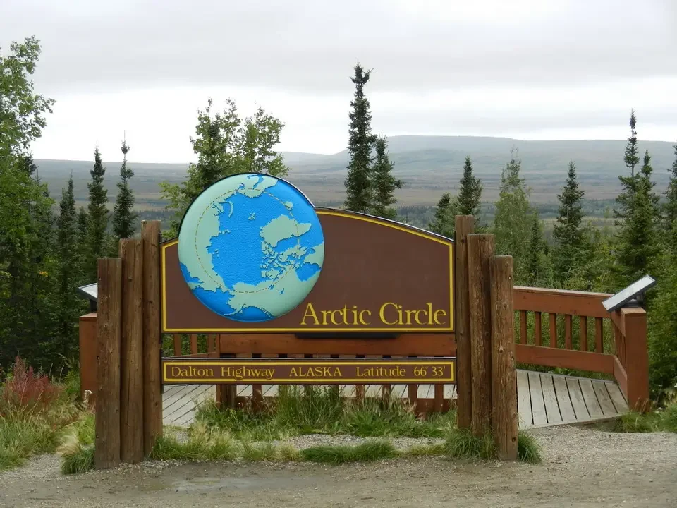 A globe map with the Arctic highlighted is mounted on a wooden sign.