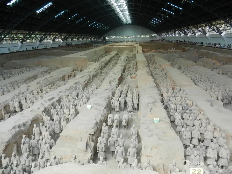 Le file di soldati della terracotta nella tomba dell'esercito cinese sono allineate in una vasta esposizione.