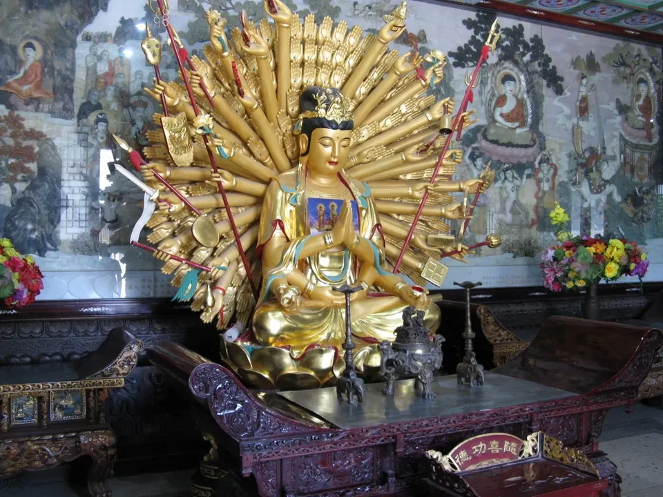 Una grande pagoda decorata con oro è raffigurata in un contesto tradizionale cinese.
