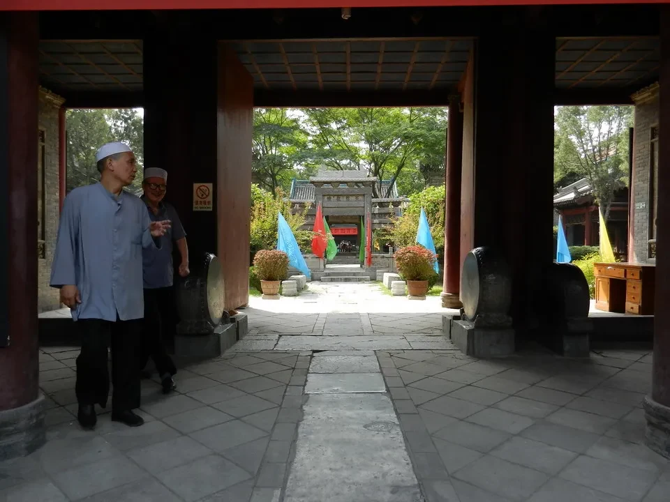 Vista di una moschea in Cina con persone che passeggiano attraverso un portico.