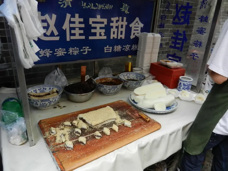 Una tavola esposta mostra una varietà di dolci e prodotti alimentari in vendita.
