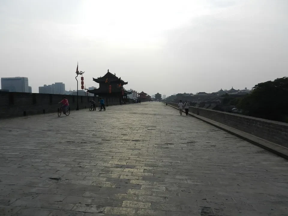 Una lunga passerella di pietra conduce lungo una muraglia storica in Cina.