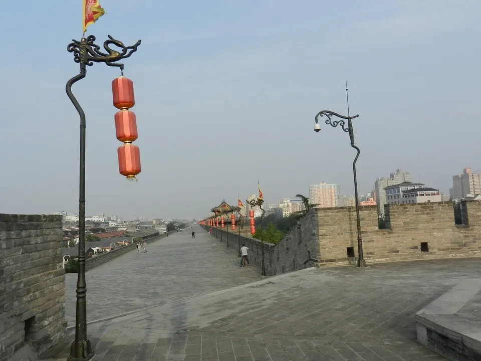 Le mura storiche di Xi'an si estendono lungo un viale con tori di lanterne rosse.