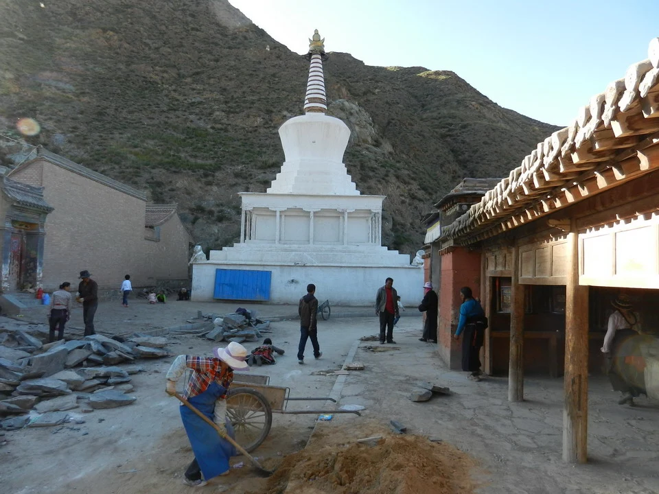 Una pagoda bianca si erge su un terreno collinare in Cina.