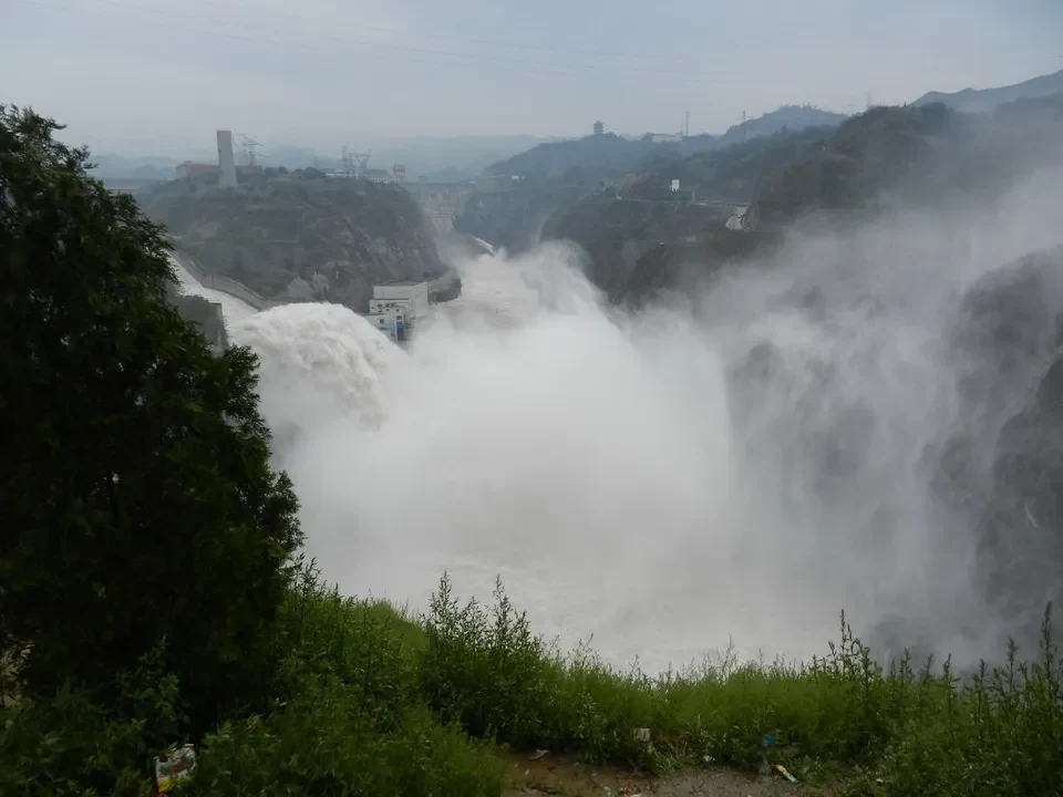 Cascata imponente con acqua che schizza tra le rocce in una valle cinese.