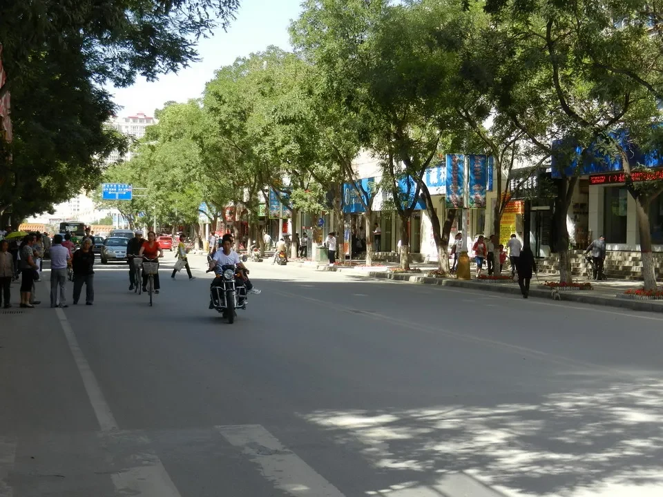 Una strada alberata con negozi lungo il marciapiede in Cina.