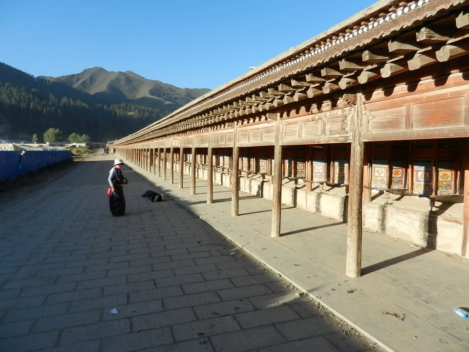 Una lunga galleria in legno si estende lungo un sentiero sotto il cielo blu.