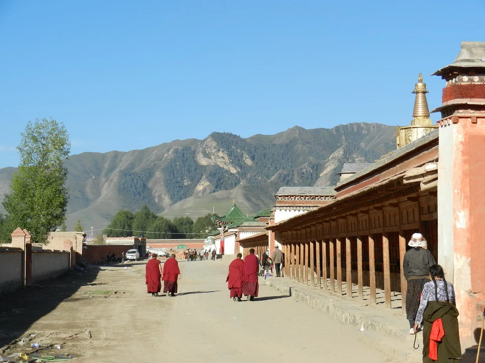 Una veduta di un percorso pedonale con edifici tradizionali e montagne sullo sfondo in Cina.