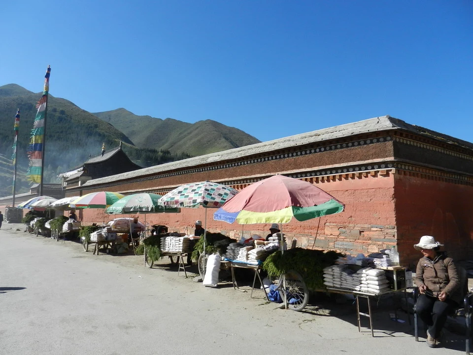 Un edificio tradizionale in mattoni lungo una strada in Cina con venditori all'aperto.