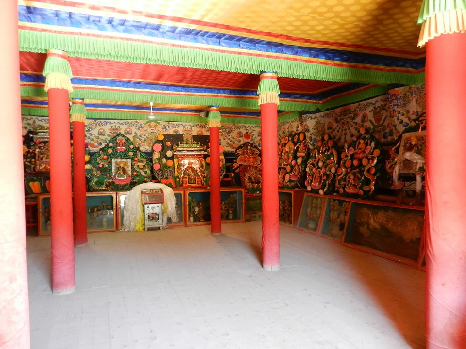 Interno di una sala con decorazioni murali tradizionali cinesi e colonne colorate.
