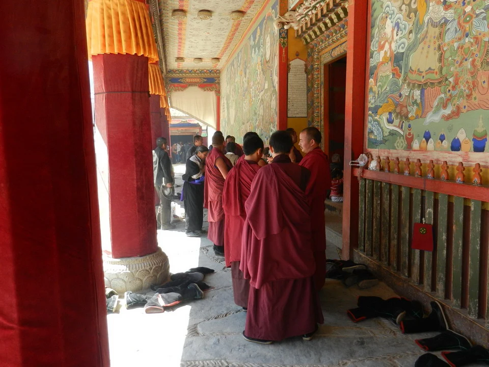 Un gruppo di uomini in abiti rossi si trova in un corridoio decorato in Cina.