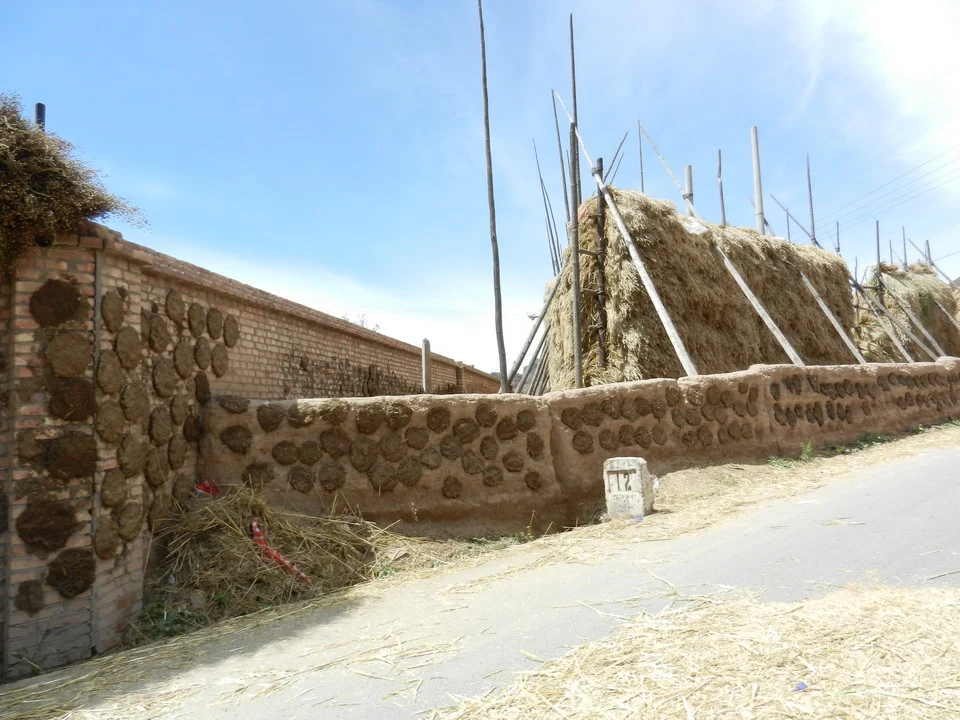 Muro di mattoni e pietra con balle di fieno in Cina.