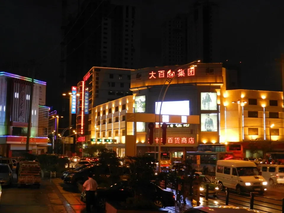Una veduta notturna di una strada cittadina con edifici commerciali illuminati in Cina.
