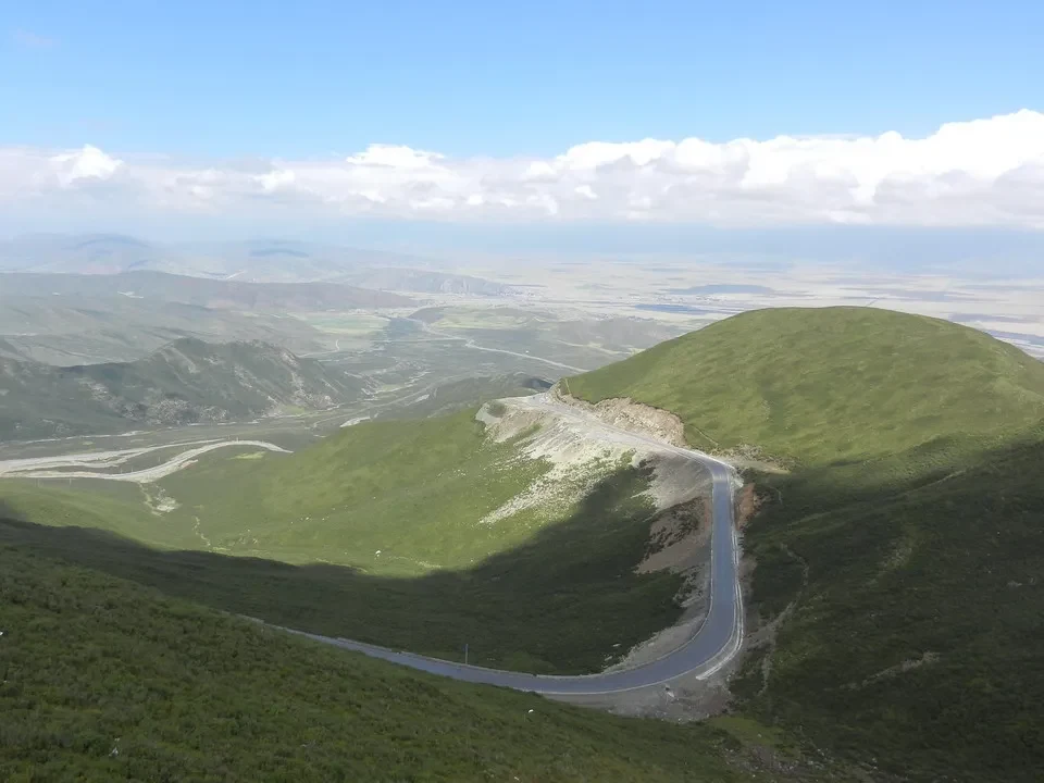 Una strada serpeggia attraverso un paesaggio collinare e montuoso in Cina.