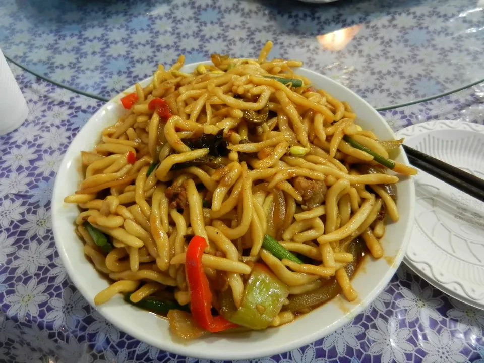 Un piatto di noodle con verdure è presentato su un tavolo in Cina.
