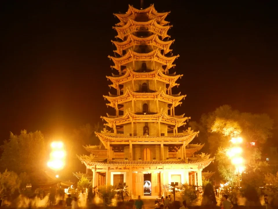 Una pagoda dorata con molti livelli è illuminata di notte in Cina.