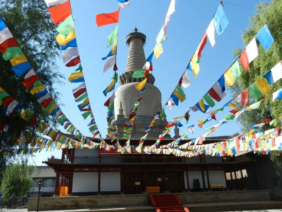 Un tempio cinese decorato con striscioni colorati si staglia sotto il cielo azzurro.