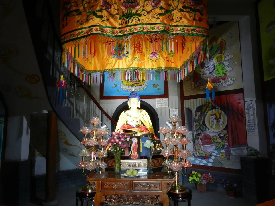 Una galleria fotografica di un tempio cinese mostra decorazioni vivaci e statue religiose.