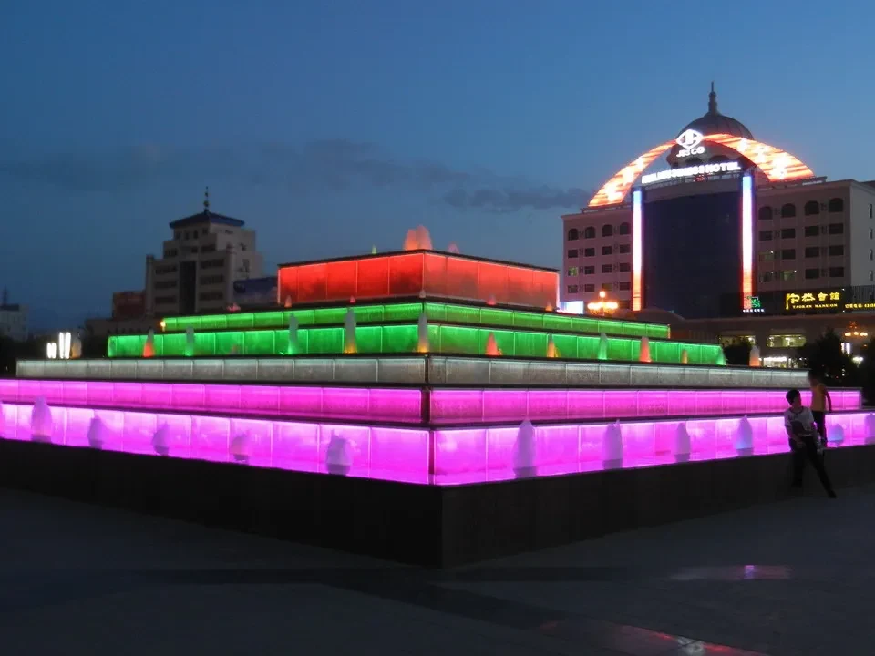 Vista notturna del complesso alberghiero di Jiayuguan con illuminazione colorata.