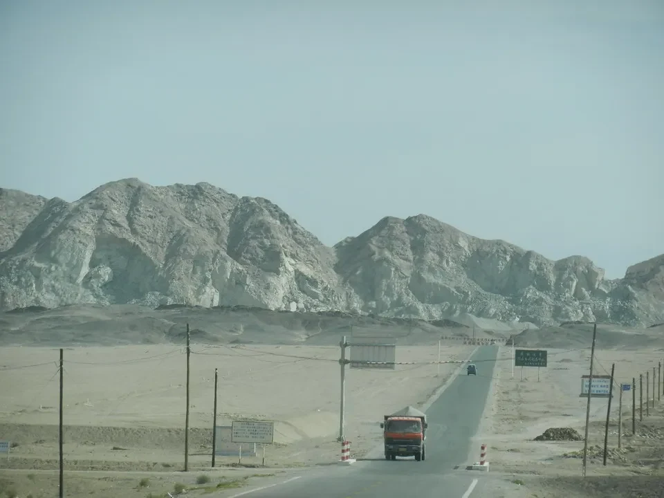 Una strada asfaltata attraversa un paesaggio desertico con montagne rocciose in Cina.