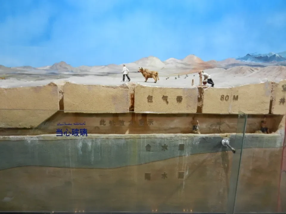Persone e un animale si trovano su una piattaforma di terra secca in un paesaggio arido.