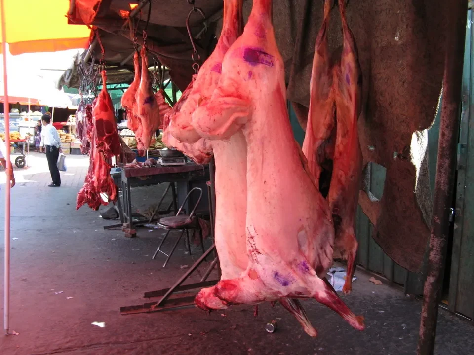 Maiali freschi appesi in un mercato cinese.