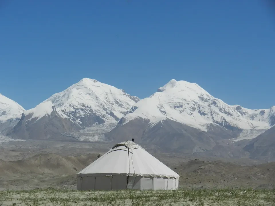 Una tenda bianca si trova in un paesaggio montano innevato in Cina.
