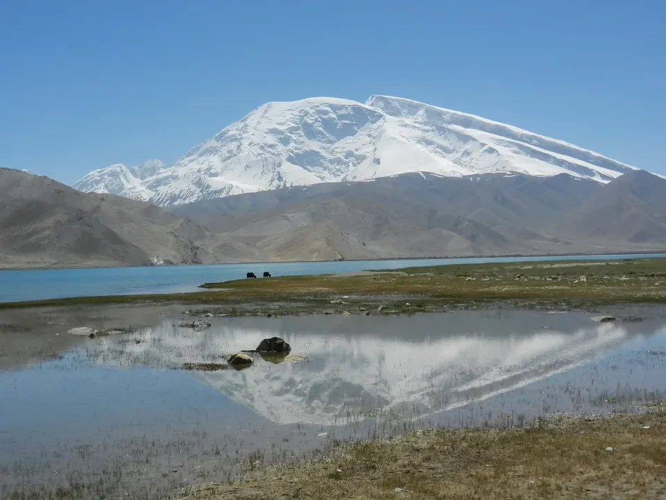 Un lago alpino circondato da montagne innevate in Cina.