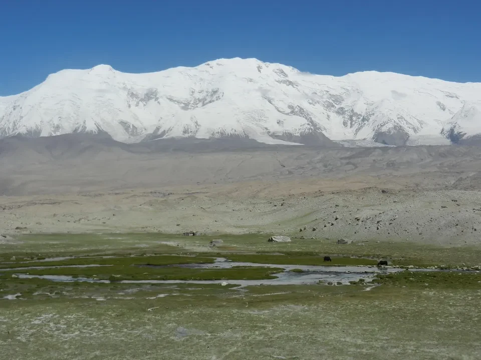 Paesaggio montano innevato con pianura erbosa in Cina.