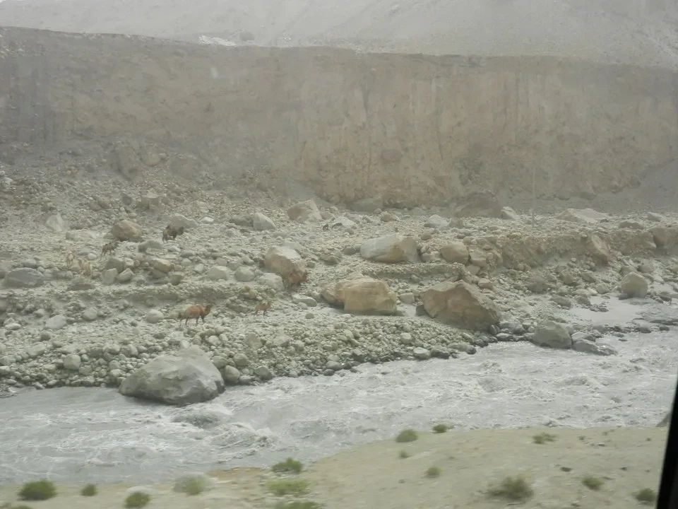 Un fiume scorre attraverso un letto di rocce e terreno arido in Cina.