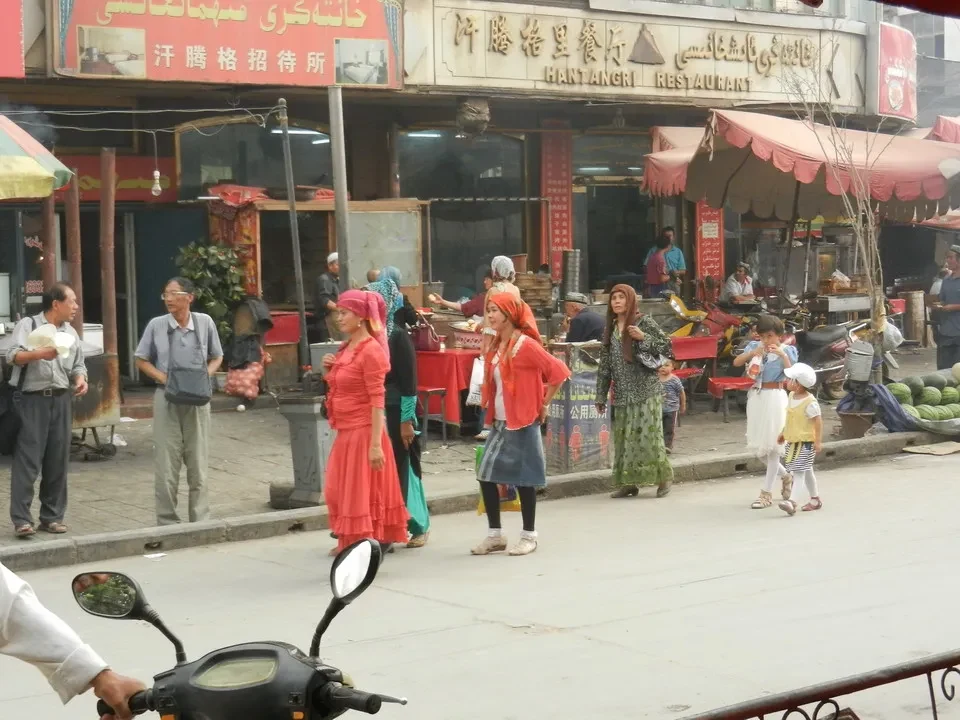 Mercato vivace con persone che passeggiano e commerciano in una strada cinese.