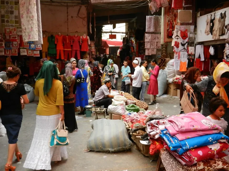 Mercato vibrante con bancarelle di tessuti e abiti in una città cinese.