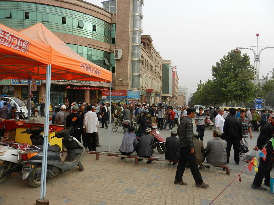 Una folla di persone cammina lungo una strada cittadina in Cina.