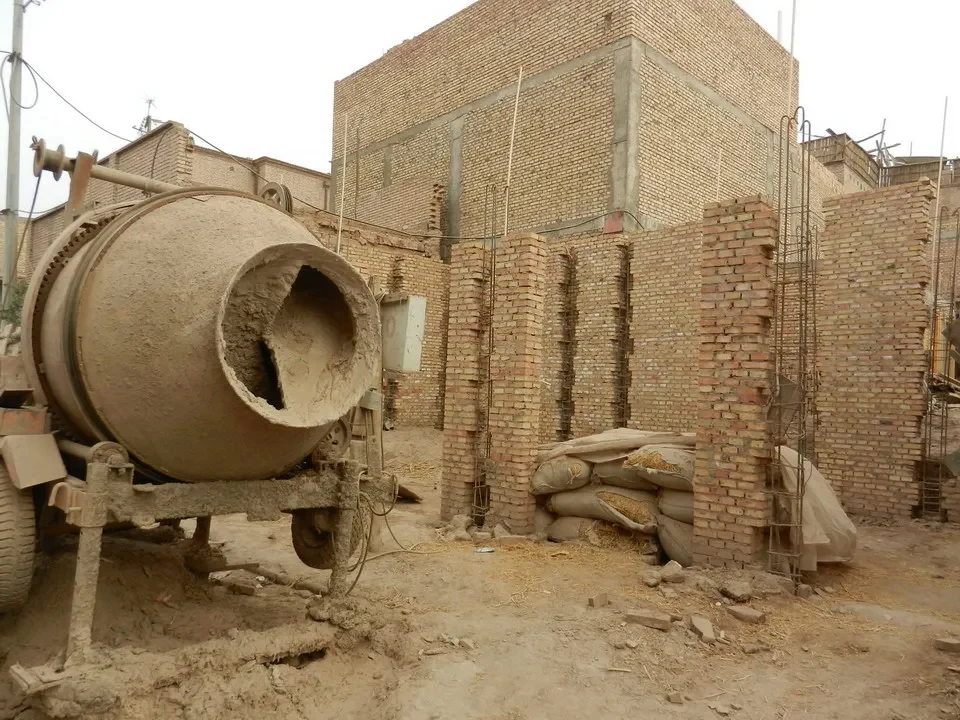 Un camion trasporta grandi cilindri di argilla in un cantiere.