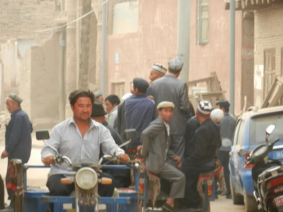 Uomini seduti su biciclette in una strada cittadina.