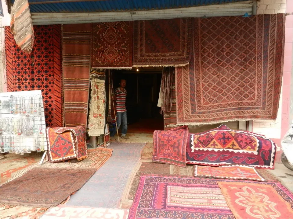 Un mercato tradizionale in Kashgar con tappeti esposti.