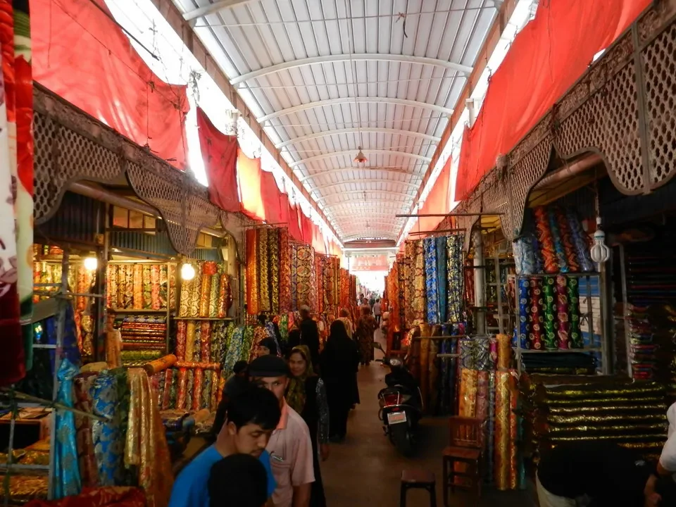 Una galleria coperta piena di mercanti espone tessuti colorati in Cina.